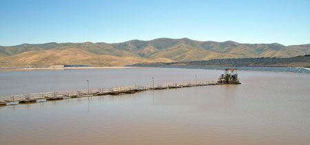 Water recovery from a conventional impoundment using a floating pontoon and walkway